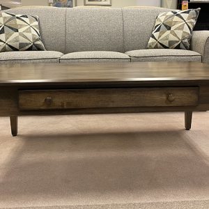 Wooden coffee table and gray couch in showroom.