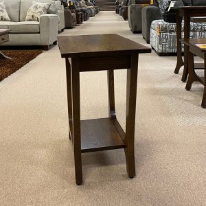 Wooden end table in furniture showroom aisle.