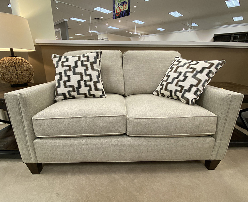 Gray sofa with geometric patterned pillows in showroom.