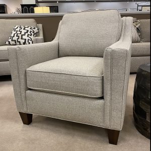 Gray armchair with geometric cushion in showroom