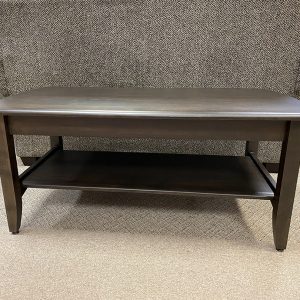 Wooden coffee table with lower shelf in showroom.