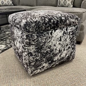 Cowhide ottoman in living room with gray sofa.