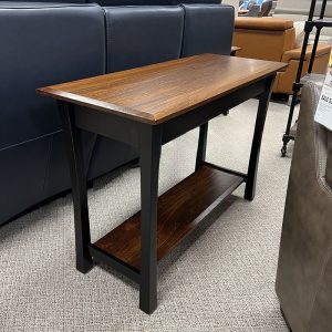 Wooden console table with lower shelf in store.