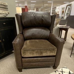 Brown leather armchair in showroom setting.