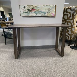 Wooden console table with abstract art above.