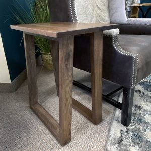 Wooden side table beside armchair in living room.