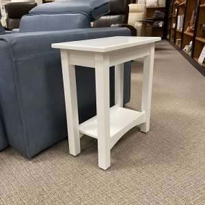 White side table next to blue sofa in store.