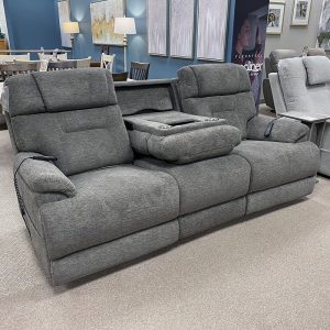 Gray reclining sofa with cup holders in showroom.