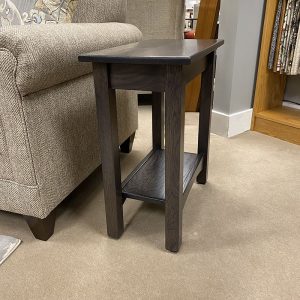 Dark wooden side table beside beige sofa