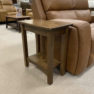 Small wooden side table next to leather recliner.