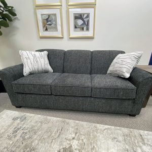Modern gray sofa with decorative pillows and art.