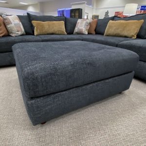 Large modern dark gray sectional sofa in showroom.