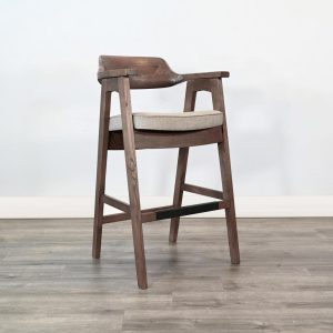 Wooden bar chair with cushion on hardwood floor.
