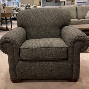 Gray upholstered armchair in a furniture showroom.