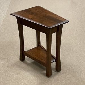 Wooden triangular accent table with lower shelf.
