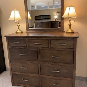 Wooden dresser with mirror and two lamps.
