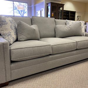 Gray modern sofa with decorative pillows in showroom.